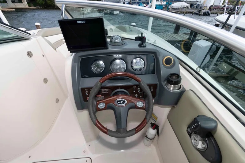 Slide: The Image of 2007 Sea Ray 260 Sundeck helm with steering wheel, gauges, and Simrad display. - 8