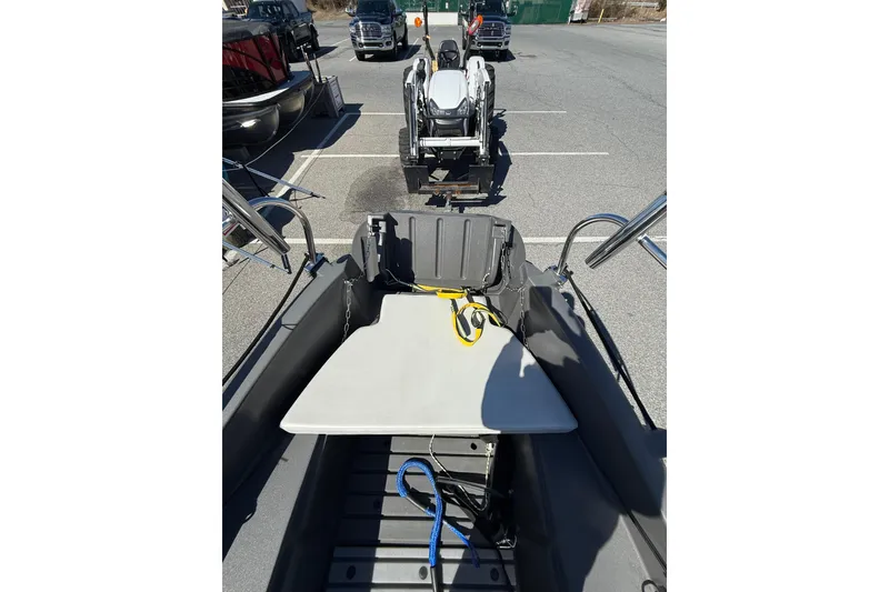 Slide: The Image of 2021 Whaly 445R boat interior with seating and equipment, parked in a lot. - 11