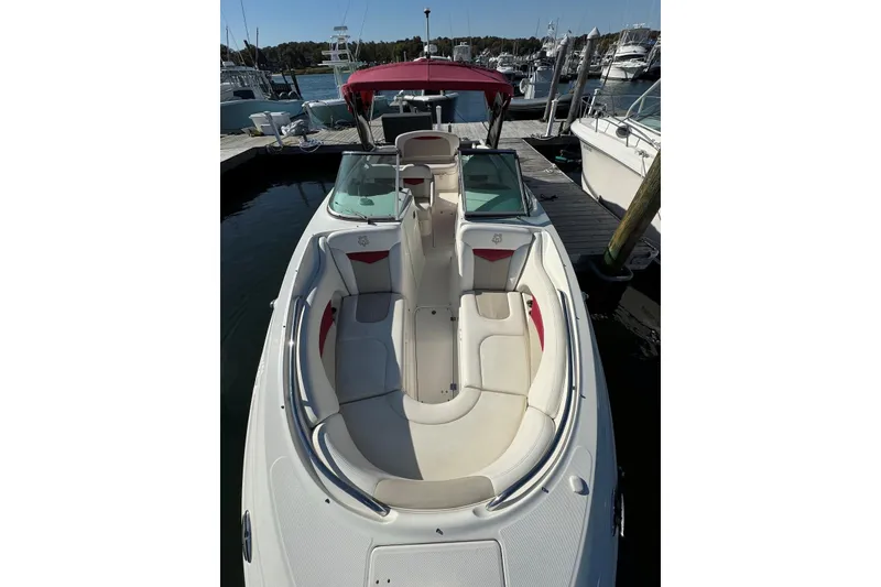 Slide: The Image of 2012 Chaparral 2870 SSX boat docked, featuring spacious seating and a red canopy. - 2