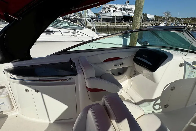 Slide: The Image of 2012 Chaparral 2870 SSX boat interior with helm and seating area at marina. - 5