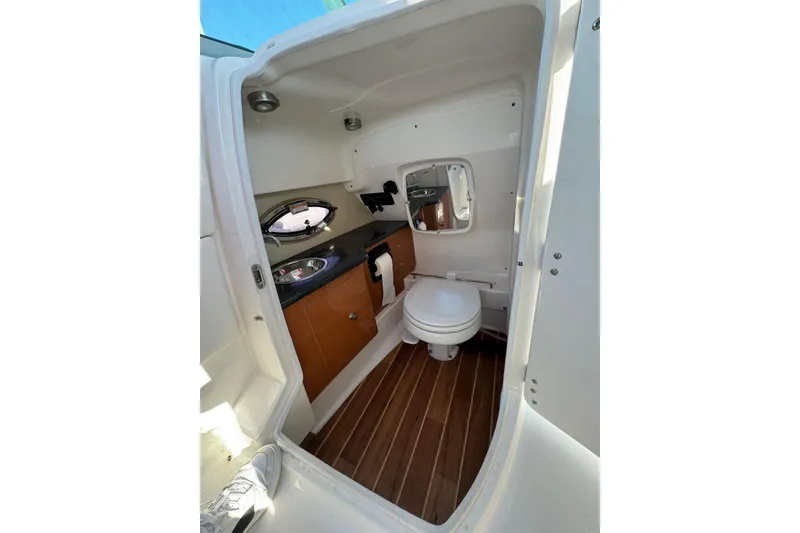 Slide: The Image of Interior of 2012 Chaparral 2870 SSX boat bathroom with sink, toilet, and wood flooring. - 7