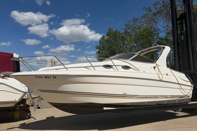 The Image of 2003 Wellcraft 2600 Martinique boat on a lift under a clear blue sky. - 1