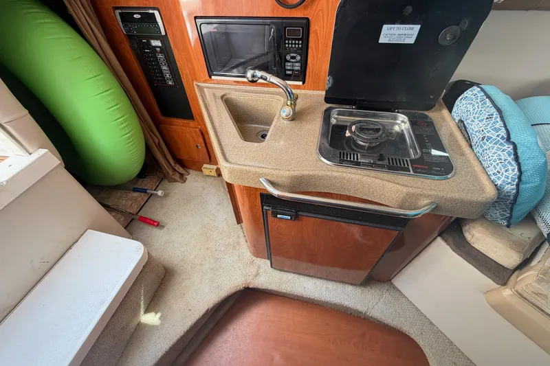 Slide: The Image of 2003 Wellcraft 2600 Martinique boat interior with kitchenette, sink, and stove. - 11