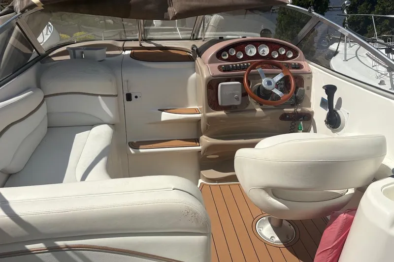 Slide: The Image of 2003 Wellcraft 2600 Martinique boat interior with white seating and wooden dashboard. - 13