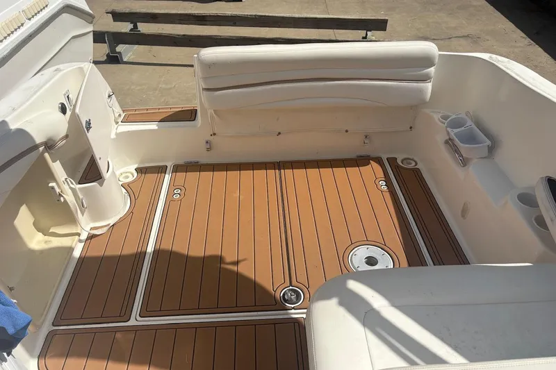 Slide: The Image of 2003 Wellcraft 2600 Martinique boat interior with teak flooring and white seating. - 14