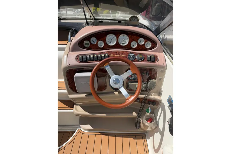 Slide: The Image of 2003 Wellcraft 2600 Martinique boat dashboard with gauges and wooden steering wheel. - 3