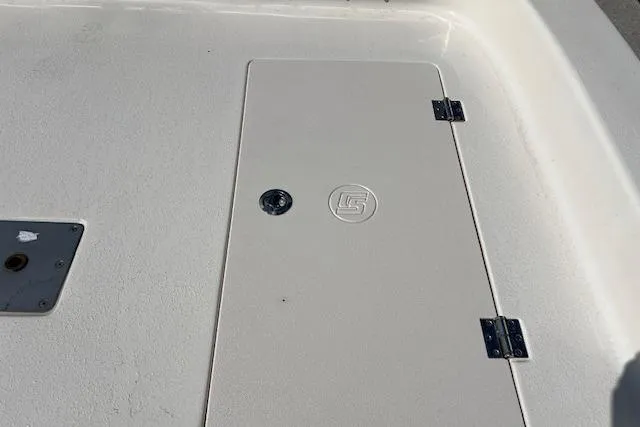 Slide: The Image of 2022 Carolina Skiff 21 LS deck hatch with hinges and logo detail. - 11