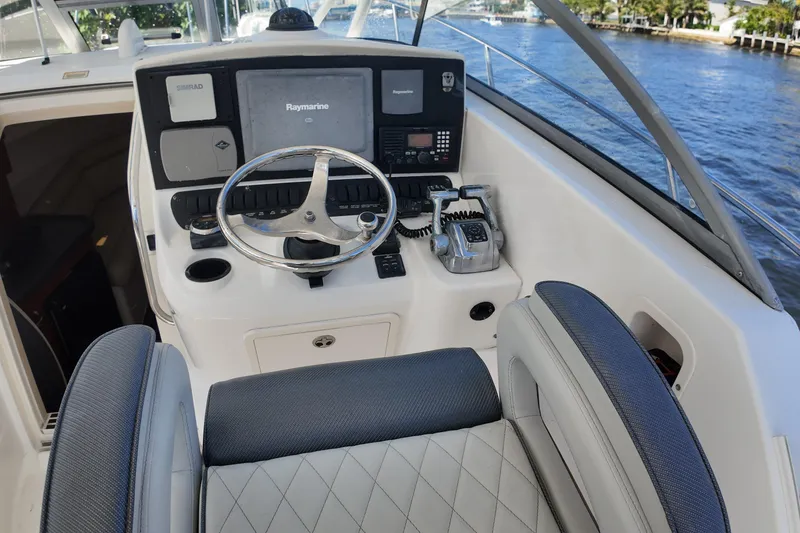 Slide: The Image of 2005 Boston Whaler 305 Conquest helm with steering wheel and navigation equipment. - 12