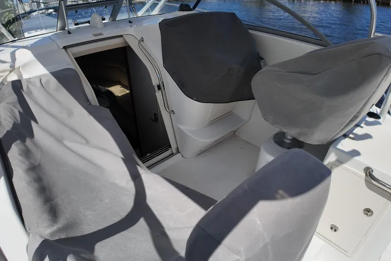 Slide: The Image of 2005 Boston Whaler 305 Conquest boat interior with covered seating and cabin entrance. - 15