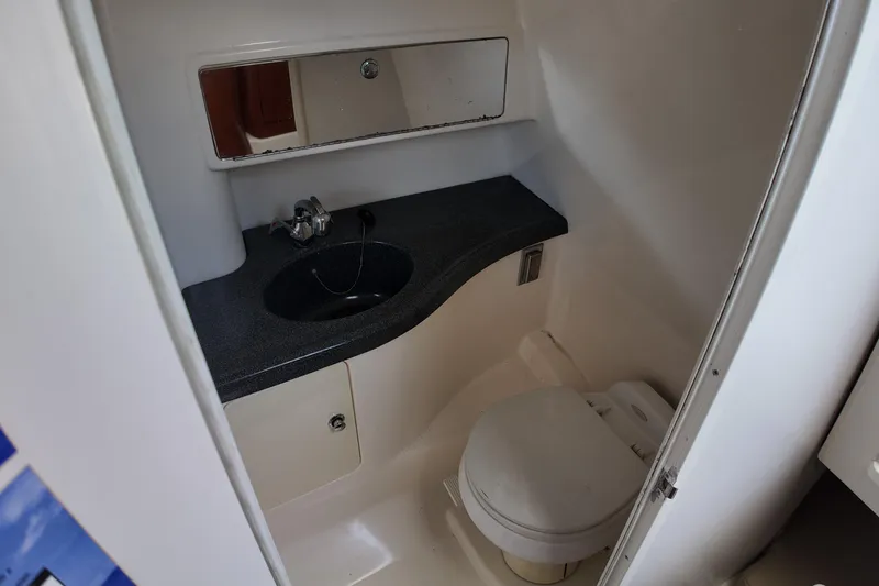 Slide: The Image of 2005 Boston Whaler 305 Conquest bathroom with sink, mirror, and toilet. - 19