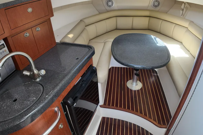 Slide: The Image of 2005 Boston Whaler 305 Conquest cabin with kitchenette and seating area. - 7