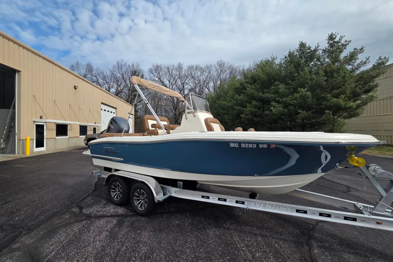 The Image of 2024 Pioneer 202 Islander boat on trailer, parked near industrial building. - 0