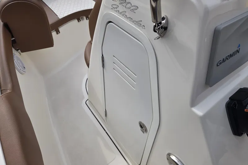 Slide: The Image of 2024 Pioneer 202 Islander boat interior with Garmin equipment and storage compartment. - 10