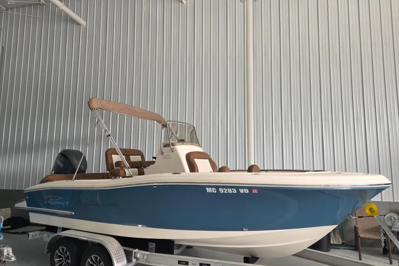 Slide: The Image of 2024 Pioneer 202 Islander boat in a storage facility, featuring a blue and white exterior. - 15