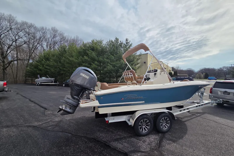 Slide: The Image of 2024 Pioneer 202 Islander boat on trailer with Yamaha engine in parking lot. - 2