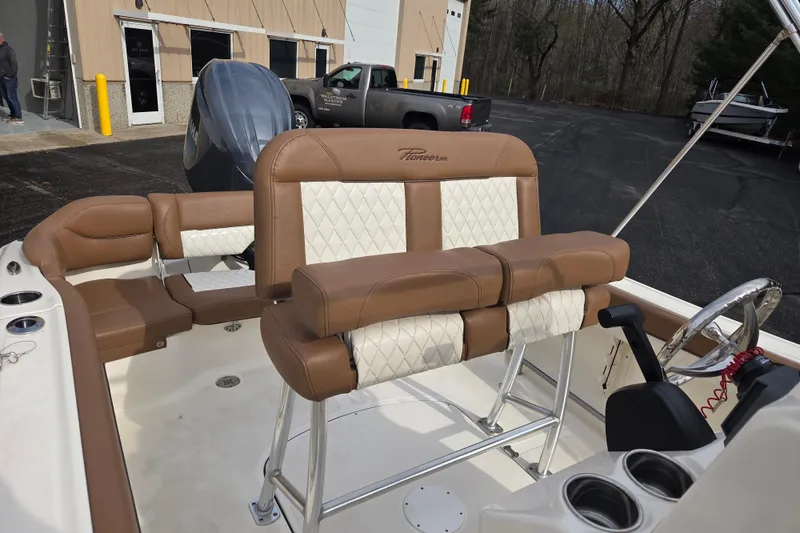 Slide: The Image of 2024 Pioneer 202 Islander boat interior with tan and white seating, steering wheel, and controls. - 4
