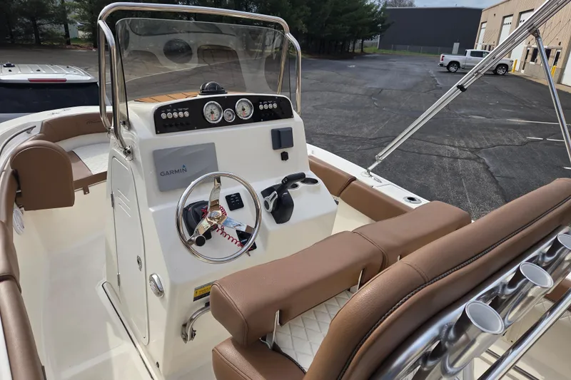 Slide: The Image of 2024 Pioneer 202 Islander boat dashboard with Garmin navigation and brown seating. - 5