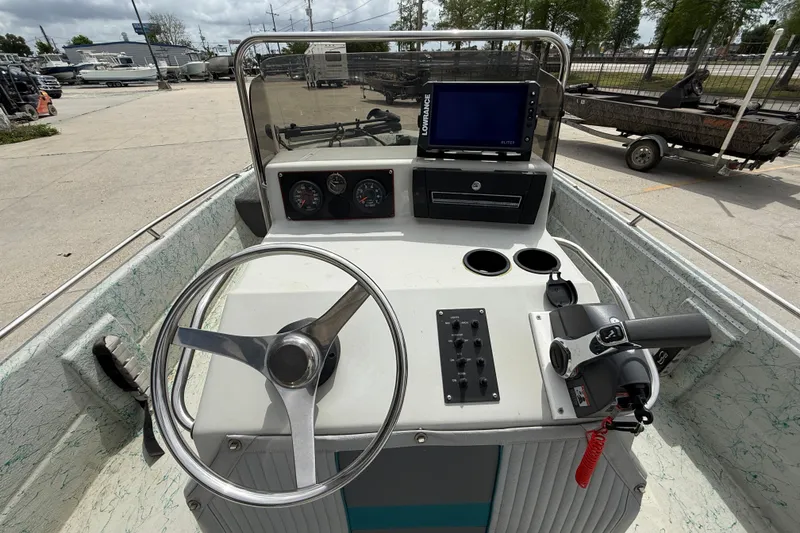 Slide: The Image of Center console of a 1998 Predator 18ft CC boat with steering wheel and controls. - 11
