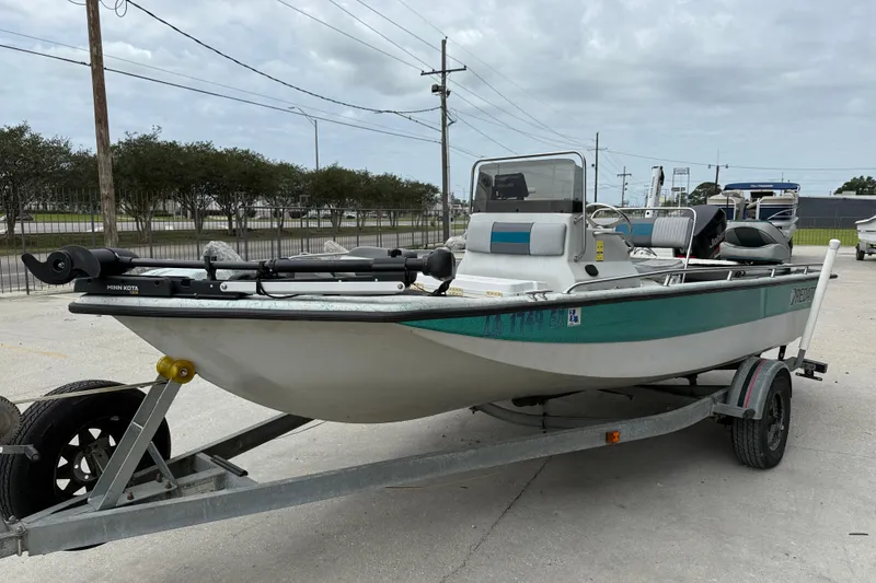 Slide: The Image of 1998 Predator 18ft CC boat on trailer, parked outdoors under cloudy sky. - 3