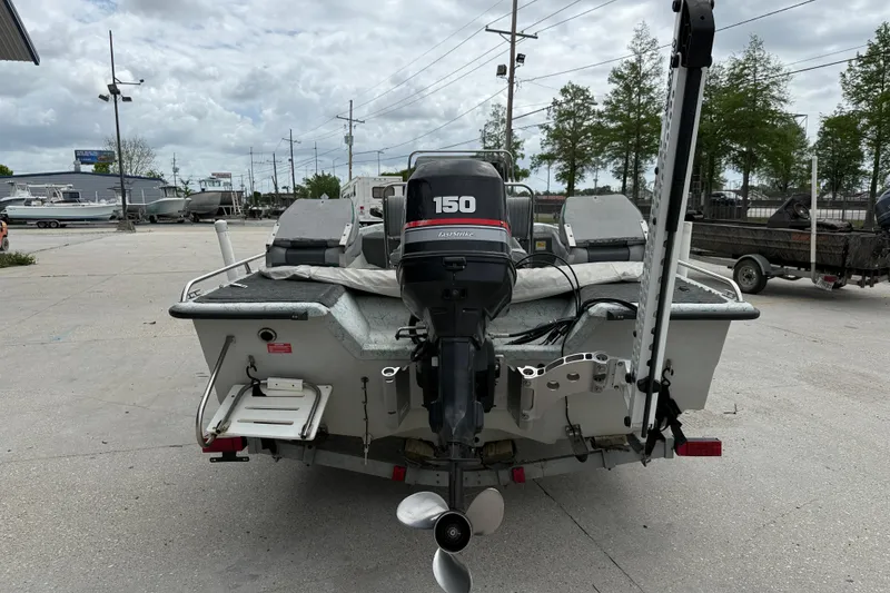 Slide: The Image of 1998 Predator 18ft CC boat with 150 horsepower engine, parked outdoors. - 5