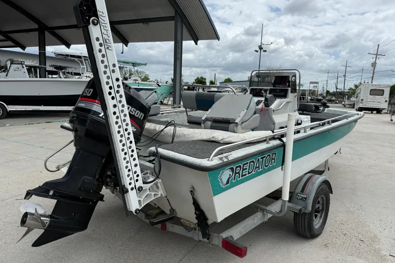 Slide: The Image of 1998 Predator 18ft CC boat with outboard motor on trailer, parked outdoors. - 6