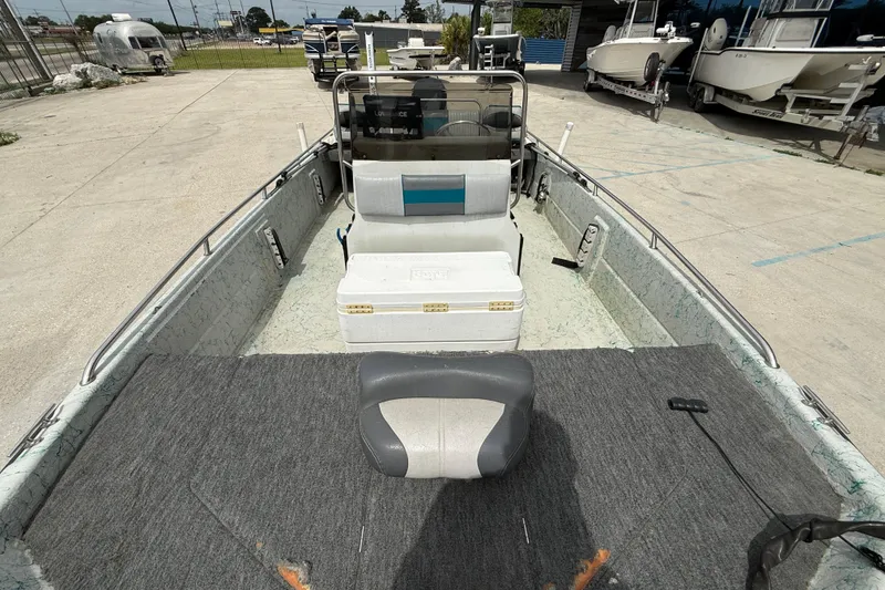 Slide: The Image of 1998 Predator 18ft CC boat interior with seating and storage, parked in a marina. - 9