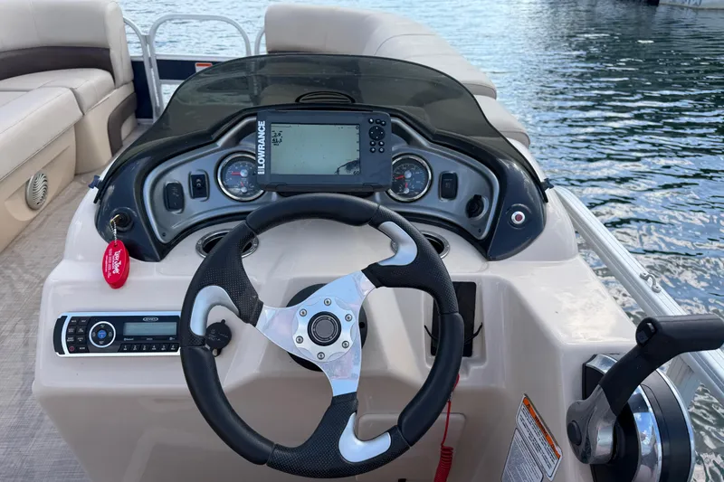 Slide: The Image of 2019 Sun Tracker Party Barge 22 Sport Fish dashboard with steering wheel and navigation system. - 10
