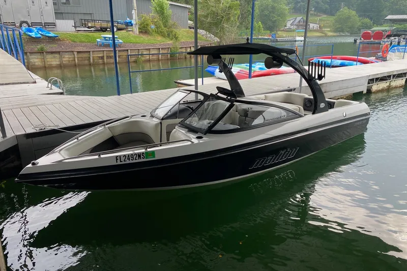 The Image of 2004 Malibu Wakesetter 21 XTi boat docked on a calm lake. - 0