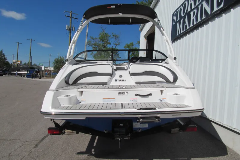 Slide: The Image of 2024 Yamaha Boats AR195, rear view, parked outside a marine store. - 4