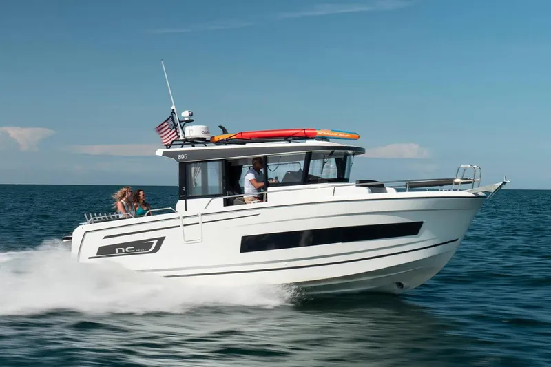 The Image of 2024 Jeanneau NC Sport 895 boat on trailer, parked outdoors under a blue sky. - 0
