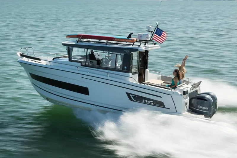 Slide: The Image of 2024 Jeanneau NC Sport 895 boat on trailer, parked outdoors under clear sky. - 2