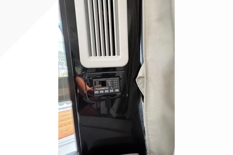 Slide: The Image of 2024 Jeanneau NC Sport 895 interior with Dometic control panel and vent. - 25