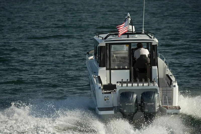 Slide: The Image of 2024 Jeanneau NC Sport 895 boat, side view, under a partly cloudy sky. - 5