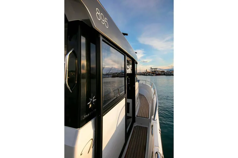 Slide: The Image of 2024 Jeanneau NC Sport 895 boat docked in a sunny marina. - 8