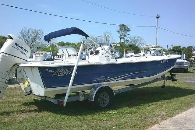 Slide: The Image of 2015 Carolina Skiff 2180 DLX boat with Suzuki outboard motor on trailer. - 6