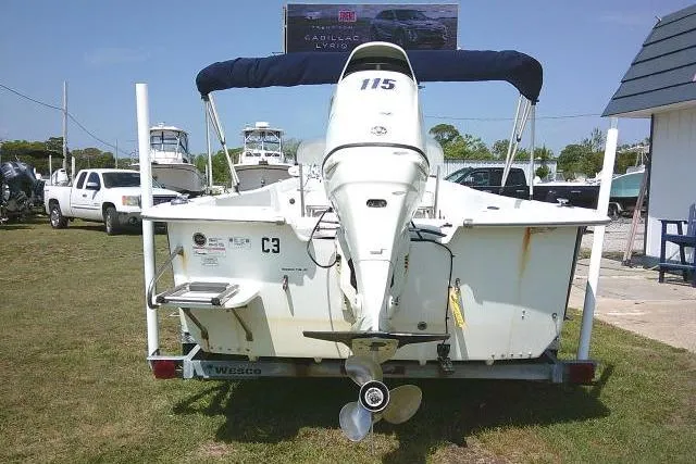 Slide: The Image of 2015 Carolina Skiff 2180 DLX boat with outboard motor, parked on grass. - 8
