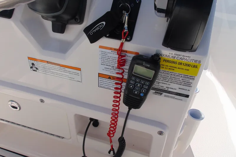 Slide: The Image of Control panel of 2025 Robalo R180 Center Console boat with safety warnings and radio. - 8