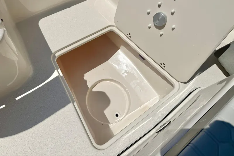 Slide: The Image of Storage compartment on 2026 Carolina Skiff 22 Ultra Elite boat, open lid, white interior. - 19