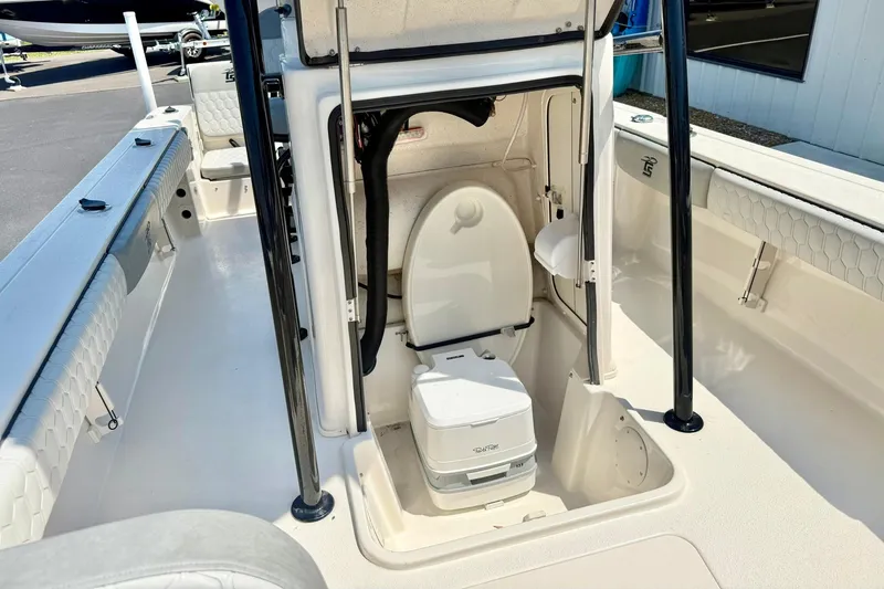 Slide: The Image of 2026 Carolina Skiff 22 Ultra Elite boat interior with portable toilet and seating area. - 21