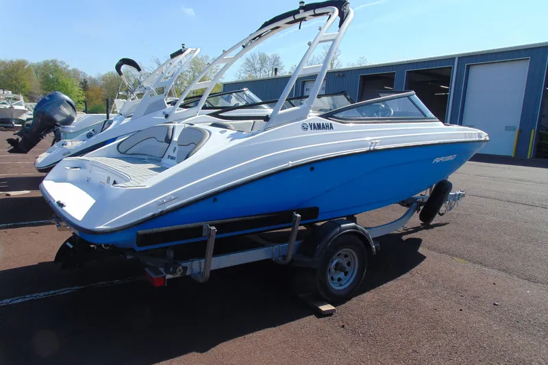 Slide: The Image of 2024 Yamaha AR190 boat on trailer, blue and white design, parked outdoors. - 3