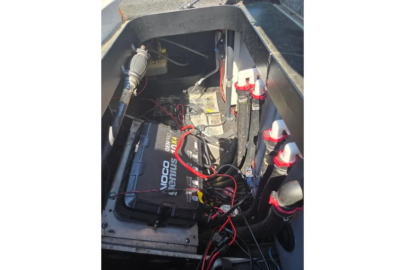 Slide: The Image of 2019 Skeeter FX21 Apex boat battery compartment with wiring and NOCO Genius charger. - 13