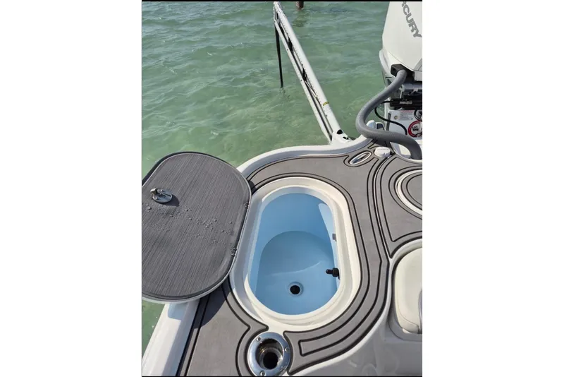 Slide: The Image of 2023 Turner Boatworks 2500VS deck with open hatch and Mercury engine in water. - 12