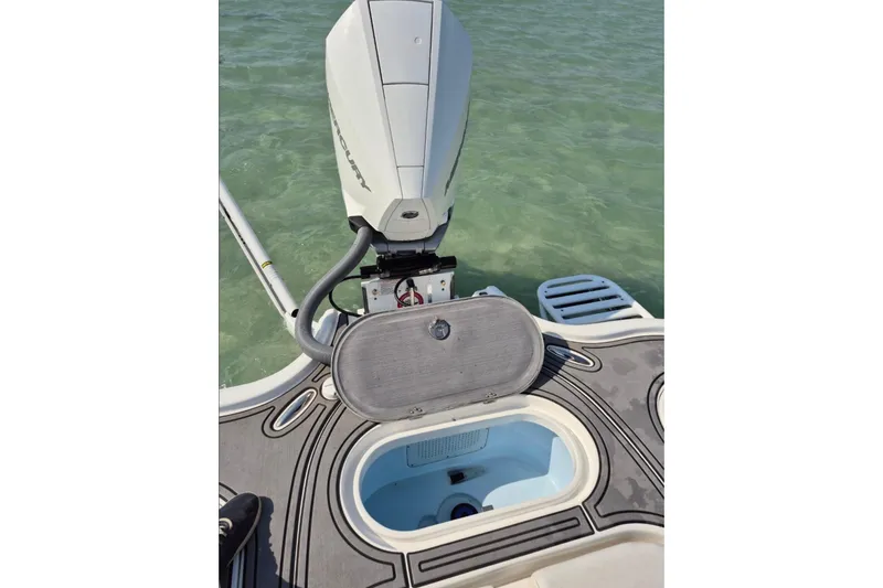 Slide: The Image of 2023 Turner Boatworks 2500VS with open hatch and outboard motor on clear water. - 13