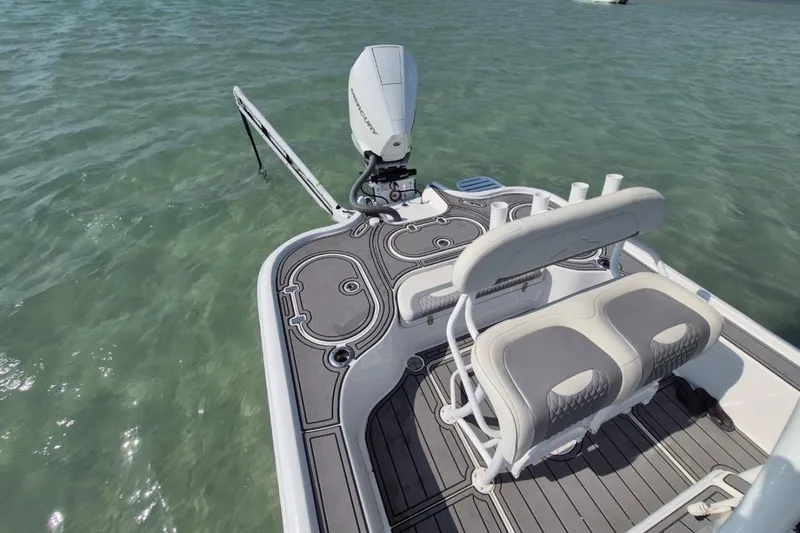 Slide: The Image of 2023 Turner Boatworks 2500VS with dual seating and motor, floating on clear water. - 7