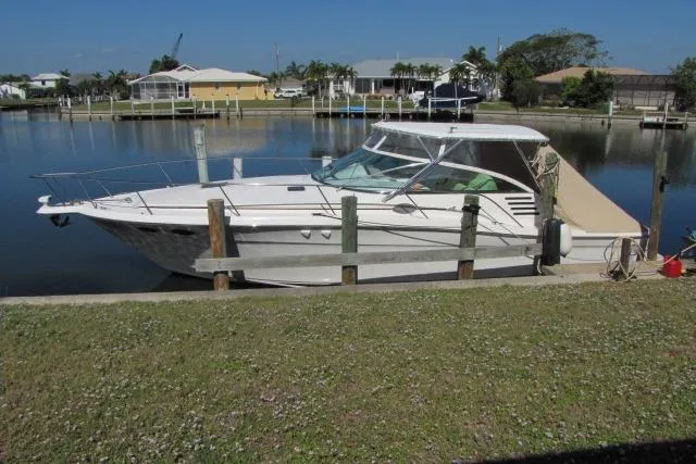 The Image of 1997 Sea Ray 370 Express Cruiser docked in a serene marina setting. - 0
