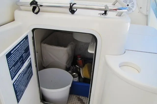 Slide: The Image of Storage compartment on a 1997 Sea Ray 370 Express Cruiser with cleaning supplies. - 14