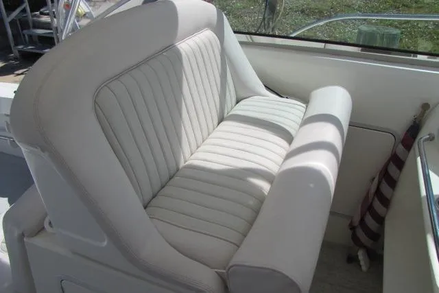 Slide: The Image of 1997 Sea Ray 370 Express Cruiser interior with white cushioned seating. - 16