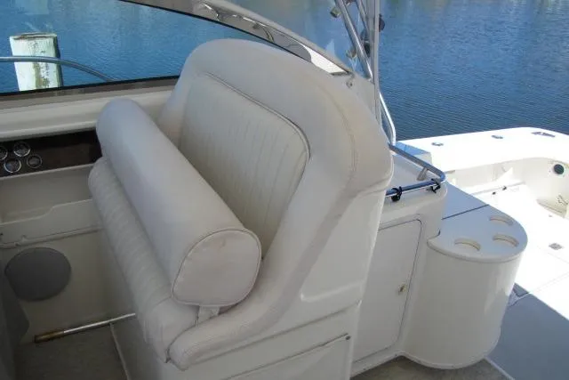 Slide: The Image of 1997 Sea Ray 370 Express Cruiser helm seat with white upholstery and cup holders. - 17