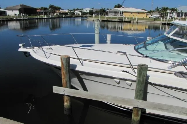 Slide: The Image of 1997 Sea Ray 370 Express Cruiser docked, showcasing spacious deck and windshield. - 2
