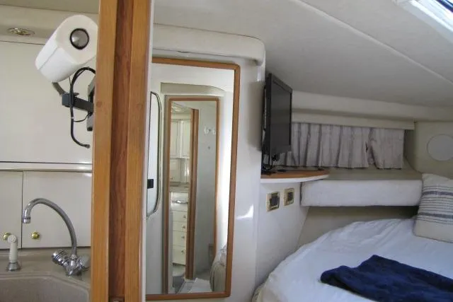Slide: The Image of Cozy cabin interior of 1997 Sea Ray 370 Express Cruiser with plush bedding. - 28